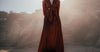 Woman in flowing silk dress standing on beach in natural sunlight — silk nightdress chemise nightgown guide Calliope Studio Australia